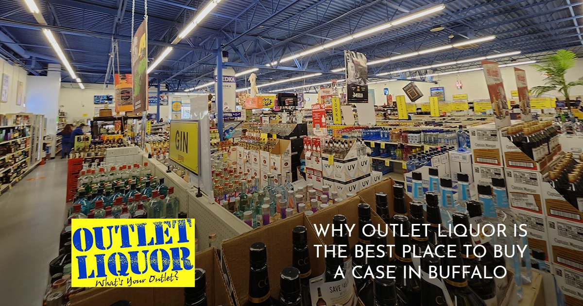 Wide view of a liquor store interior with many bottles and a bright yellow Outlet Liquor sign.