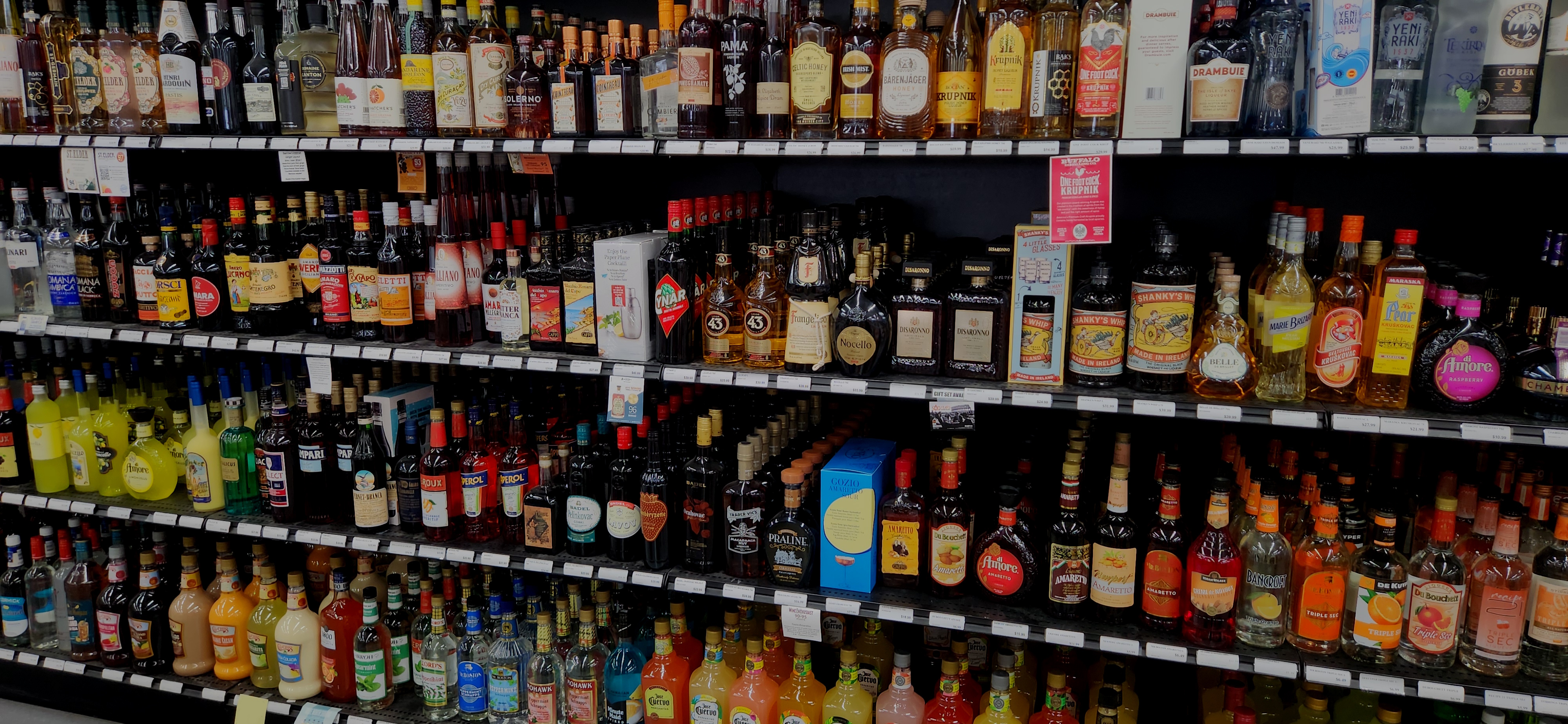 Display of various liquor bottles and boxes on shelves.